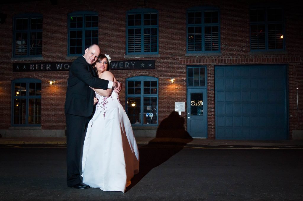 wed couple hugging outside Lowell Brewery