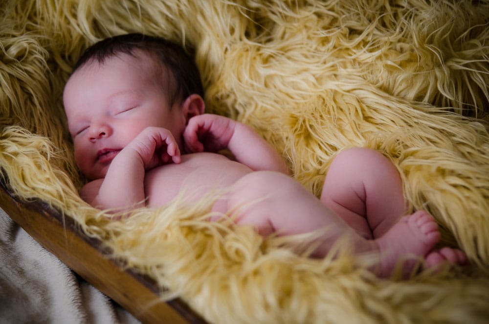 newborn sleeping on yellow fur