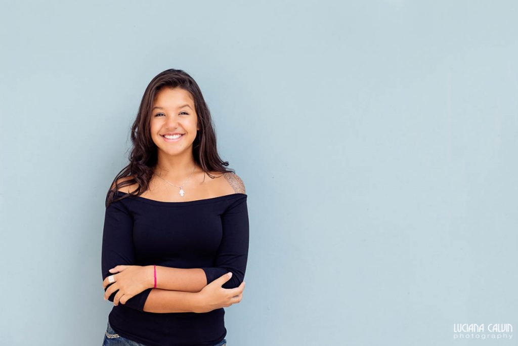 Teen in front of blue wall posing for photo shoot