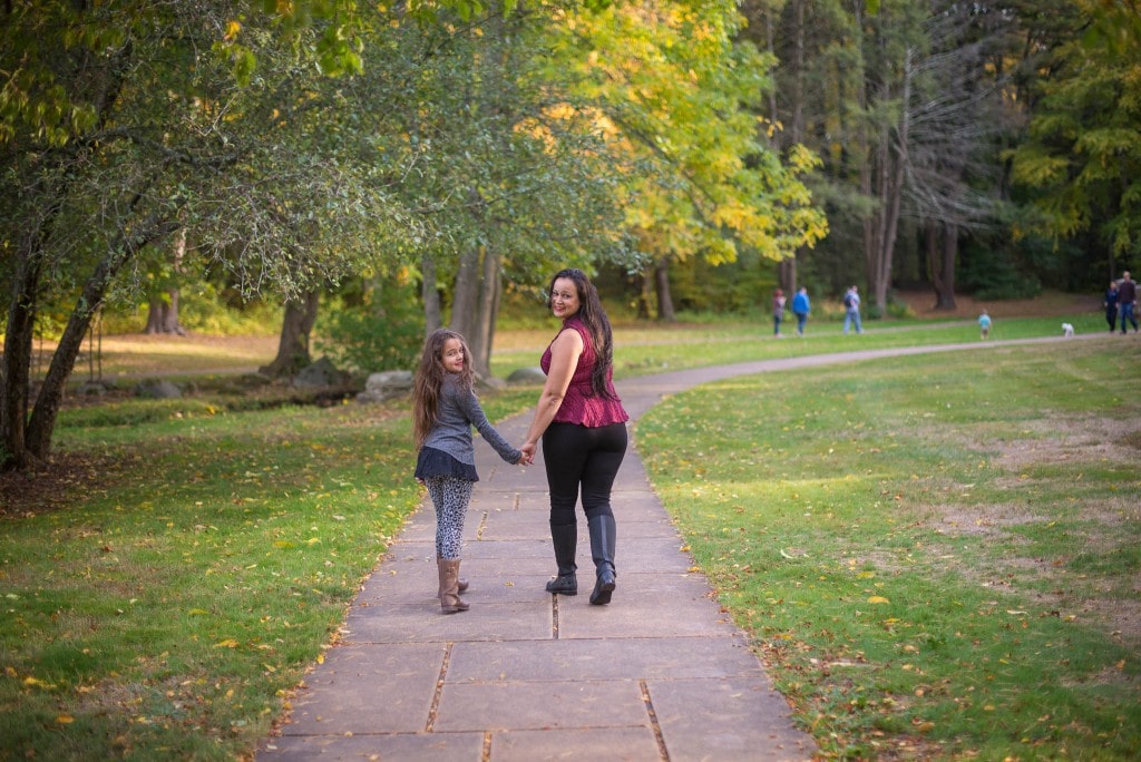 mother and daughter walking holding hands in the park