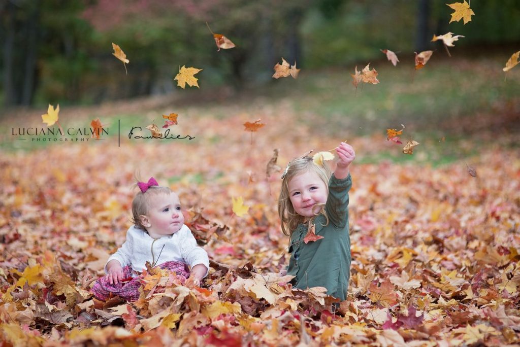 girls playing with fall leaves