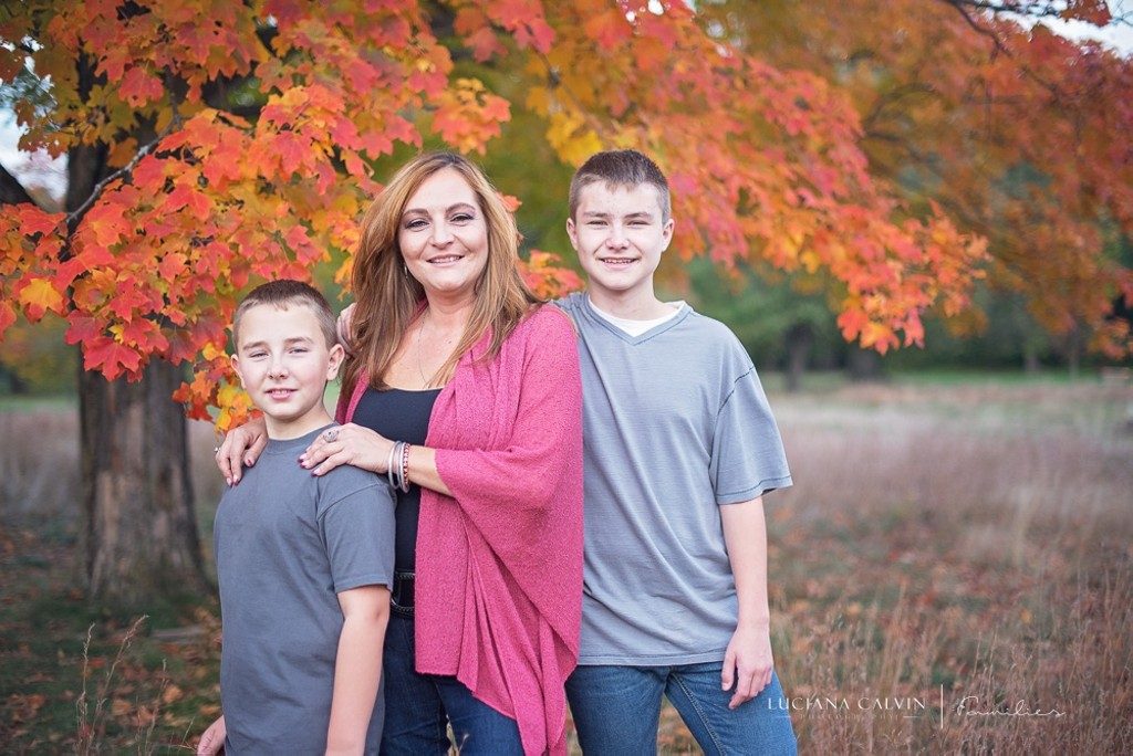 Mother and sons under a fall orange tree