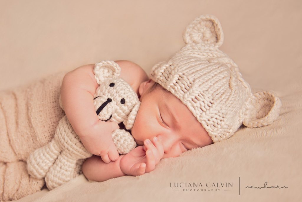 newborn sleeping with a little stuffed animal