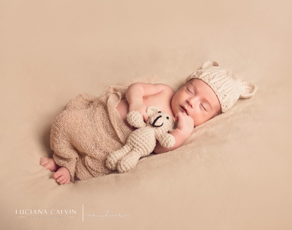 newborn sleeping with a little stuffed animal