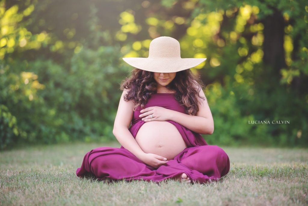 Pregnant woman seating on the grass