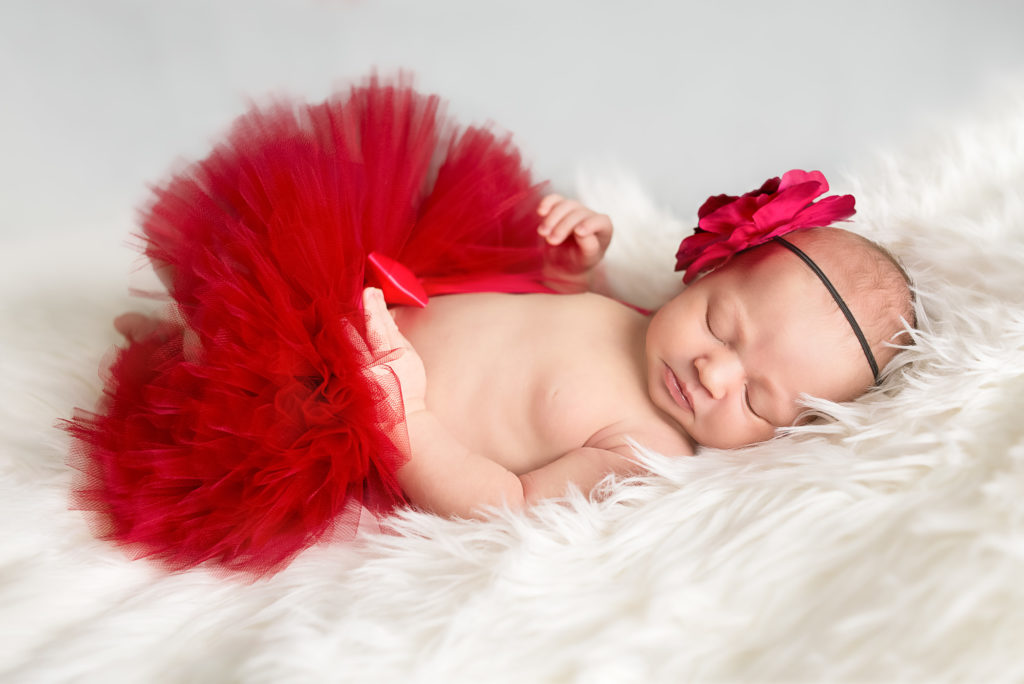 baby sleeping with red skirt