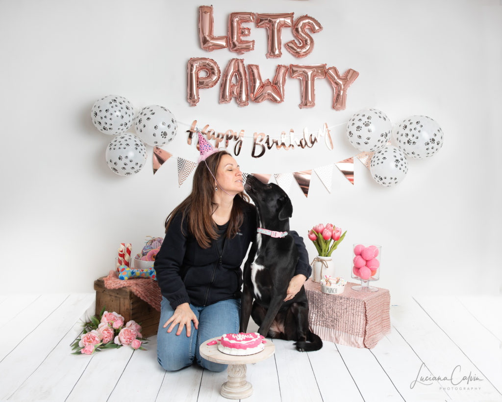 dog kissing mom with birthday hat