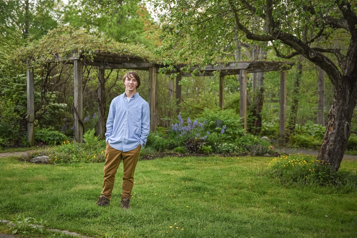 Senior portrait of a high school boy under the pergola at Acton Arboretum, Acton Massachusetts