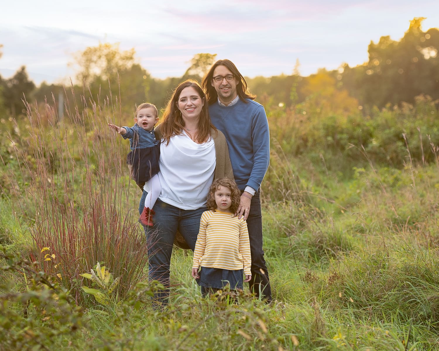 Family of four in the hayfield at sunset at Great Brook Farm State Park in Carlisle MA