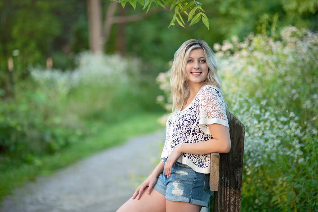 Senior portrait on the wildflower-lined gravel path at Acton Arboretum in Acton Massachusetts