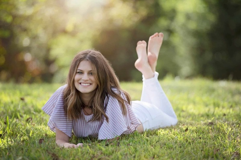 Senior pictures of girl laying in the grass on a summer day in near Chelmsford, ma