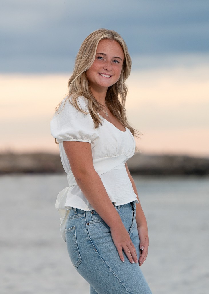 High school senior girl on the shoreline at sunset at Wingaersheek Beach in Gloucester MA