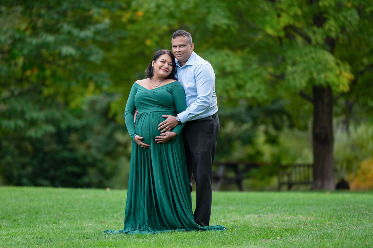 Expecting couple on the open lawn at Acton Arboretum in Acton Massachusetts