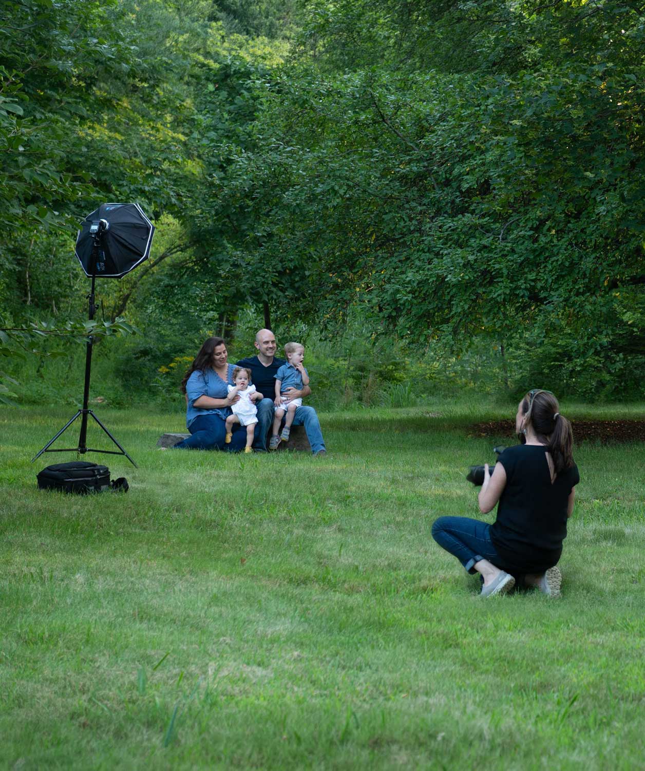 Luciana Calvin photographing a family outdoors during a portrait session in Chelmsford, MA
