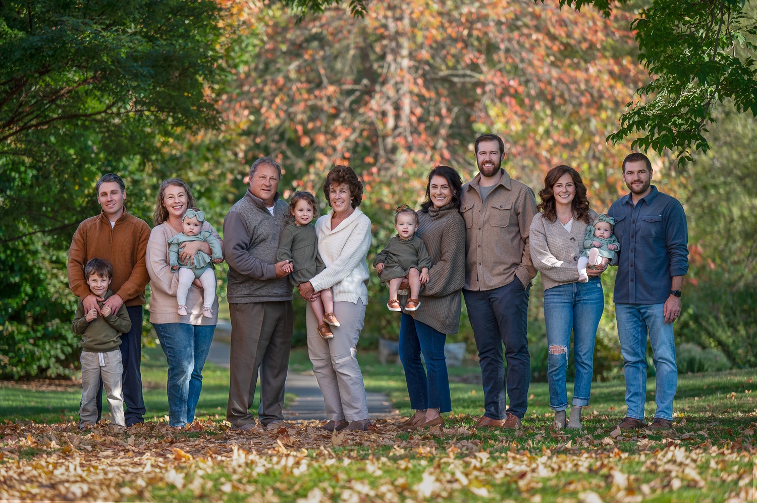 Extended family on the lawn in autumn at Acton Arboretum in Acton MA