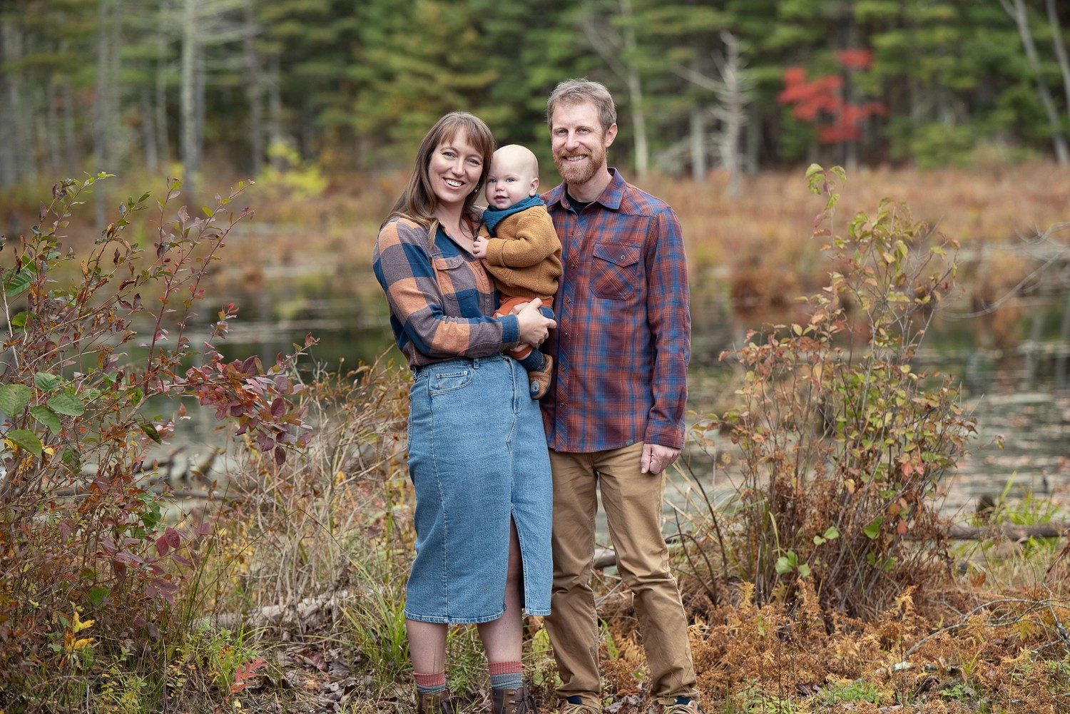 Family of three standing at the edge of an old field in autumn at Assabet River National Wildlife Refuge, Sudbury Massachusetts
