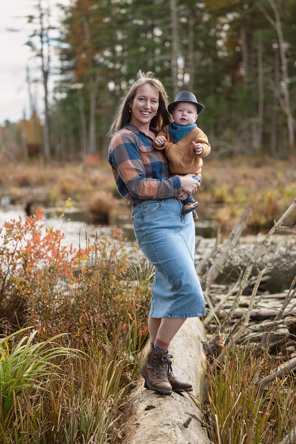 Mother holding her baby on the trail in autumn at Assabet River National Wildlife Refuge, Sudbury Massachusetts