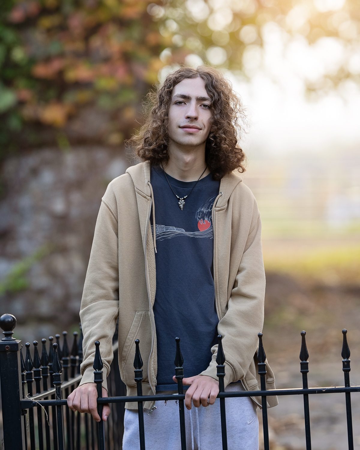 High school senior standing at the iron fence at Bancroft's Castle on Gibbet Hill in Groton MA