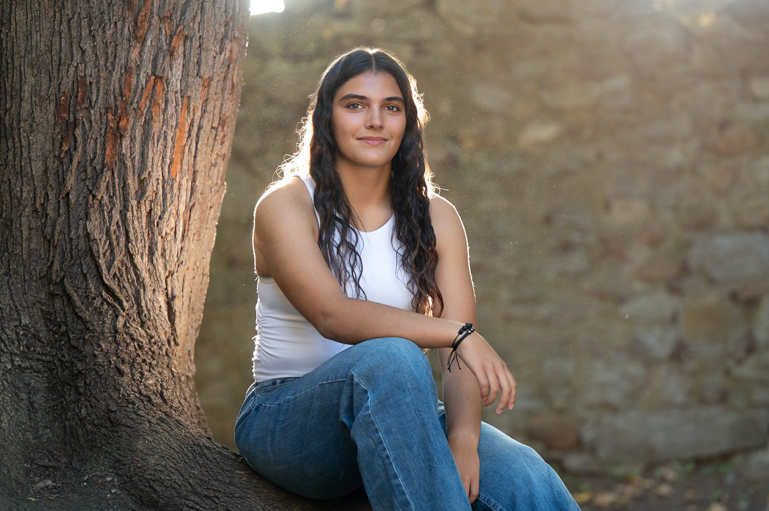 High school senior seated against the fieldstone wall of Bancroft's Castle in Groton MA
