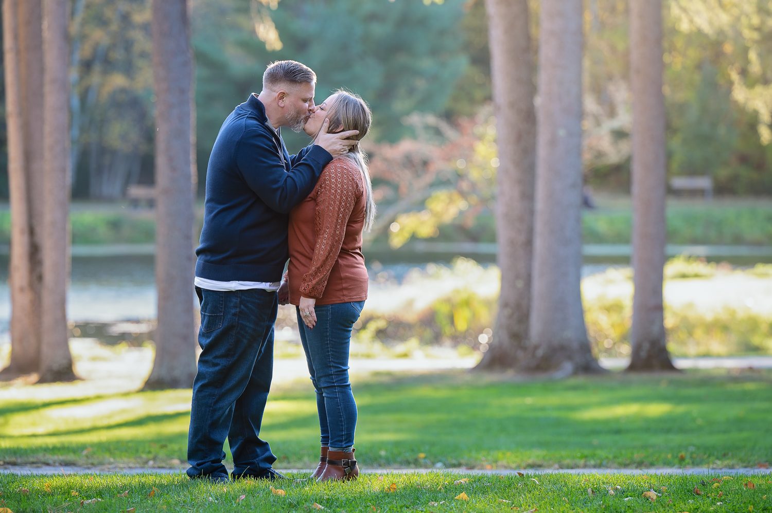 Couple holding each other by the pond in evening light at Benson Park, Hudson New Hampshire