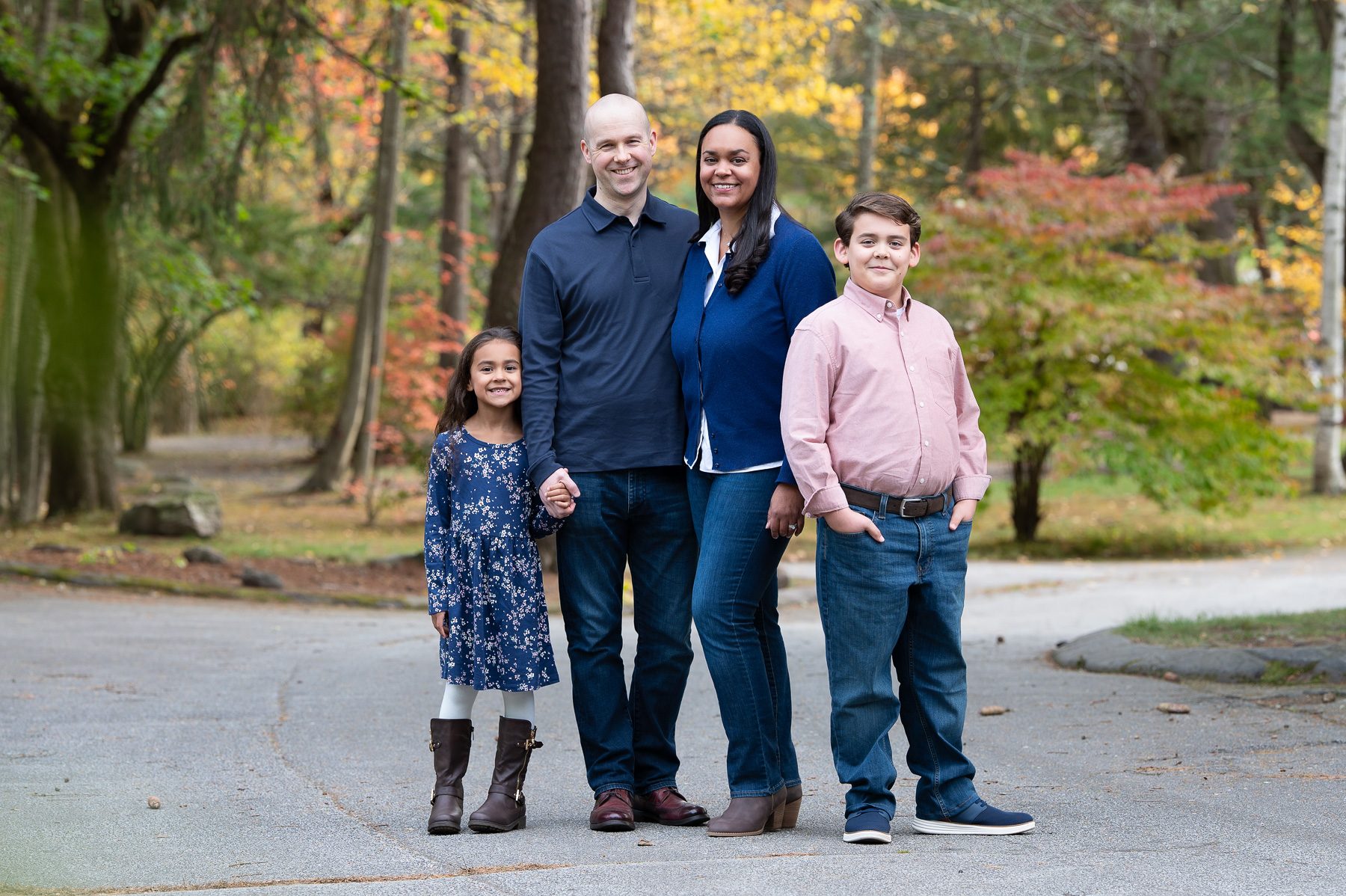Family of five standing together on the paved path in autumn at Benson Park in Hudson NH