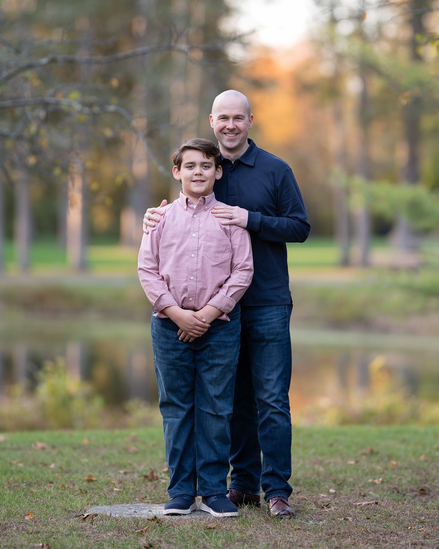 Father standing with his son backlit beside the pond at Benson Park, Hudson New Hampshire