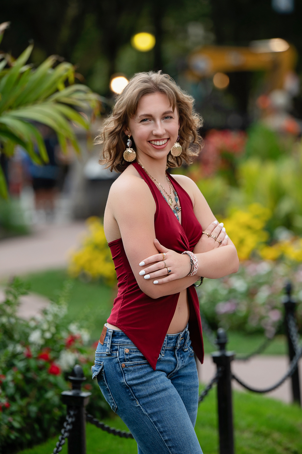 High school senior standing beside the seasonal flower beds and a globe lamp in the Boston Public Garden in Boston MA