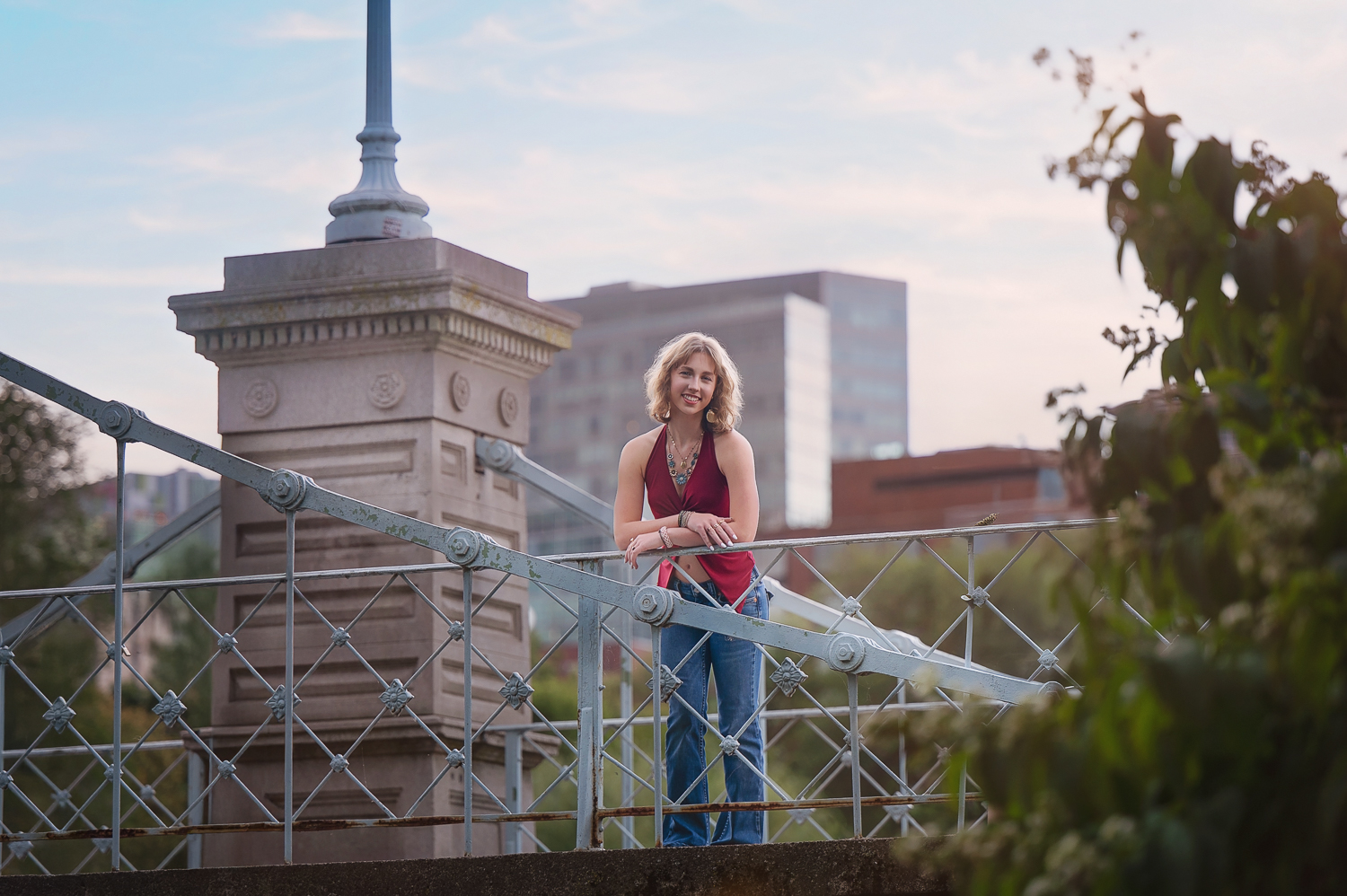 High school senior leaning on the rail of the 1867 footbridge over the lagoon in the Boston Public Garden in Boston MA