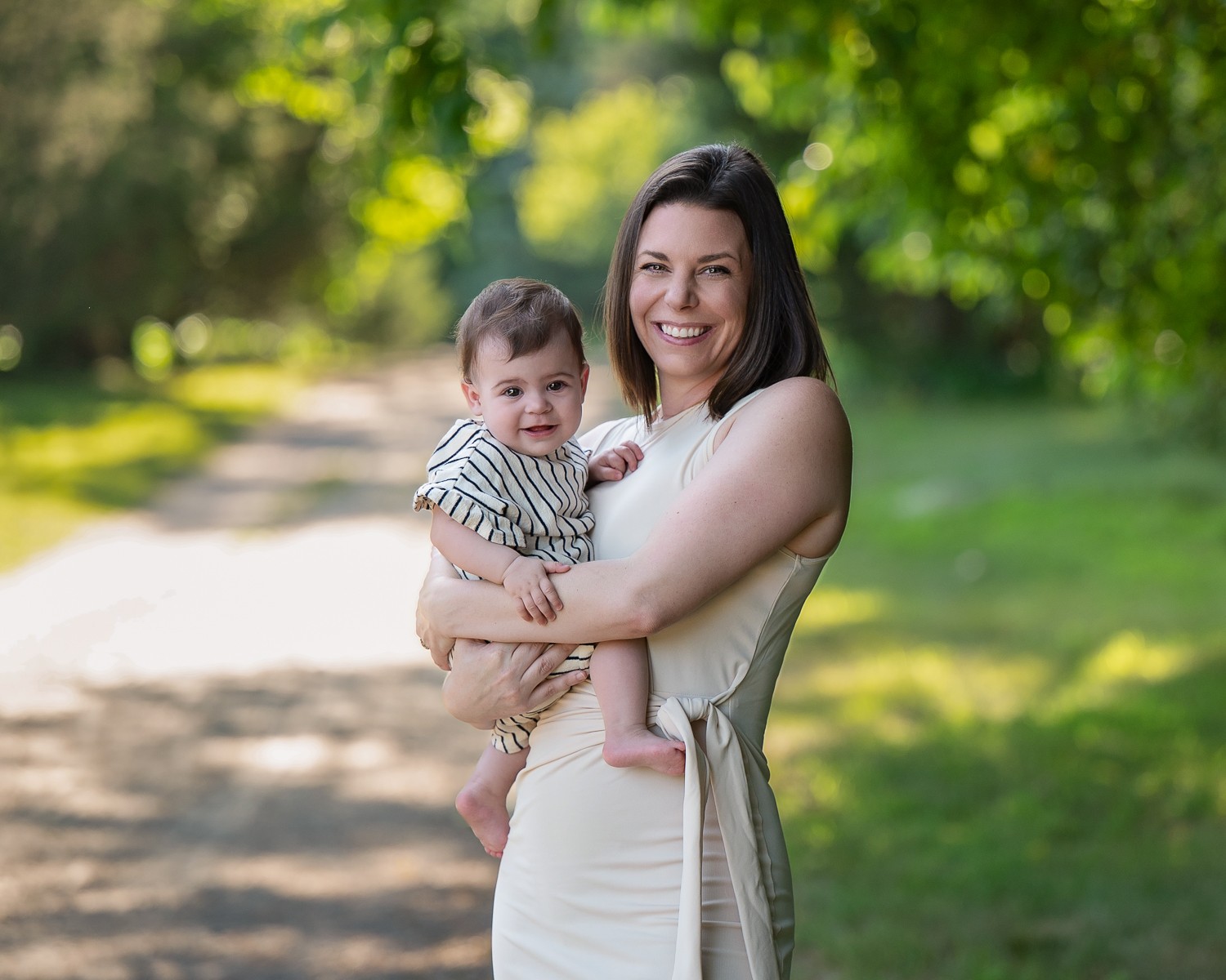 Mother holding her baby on a shaded cart path in summer at Great Brook Farm, Carlisle MA