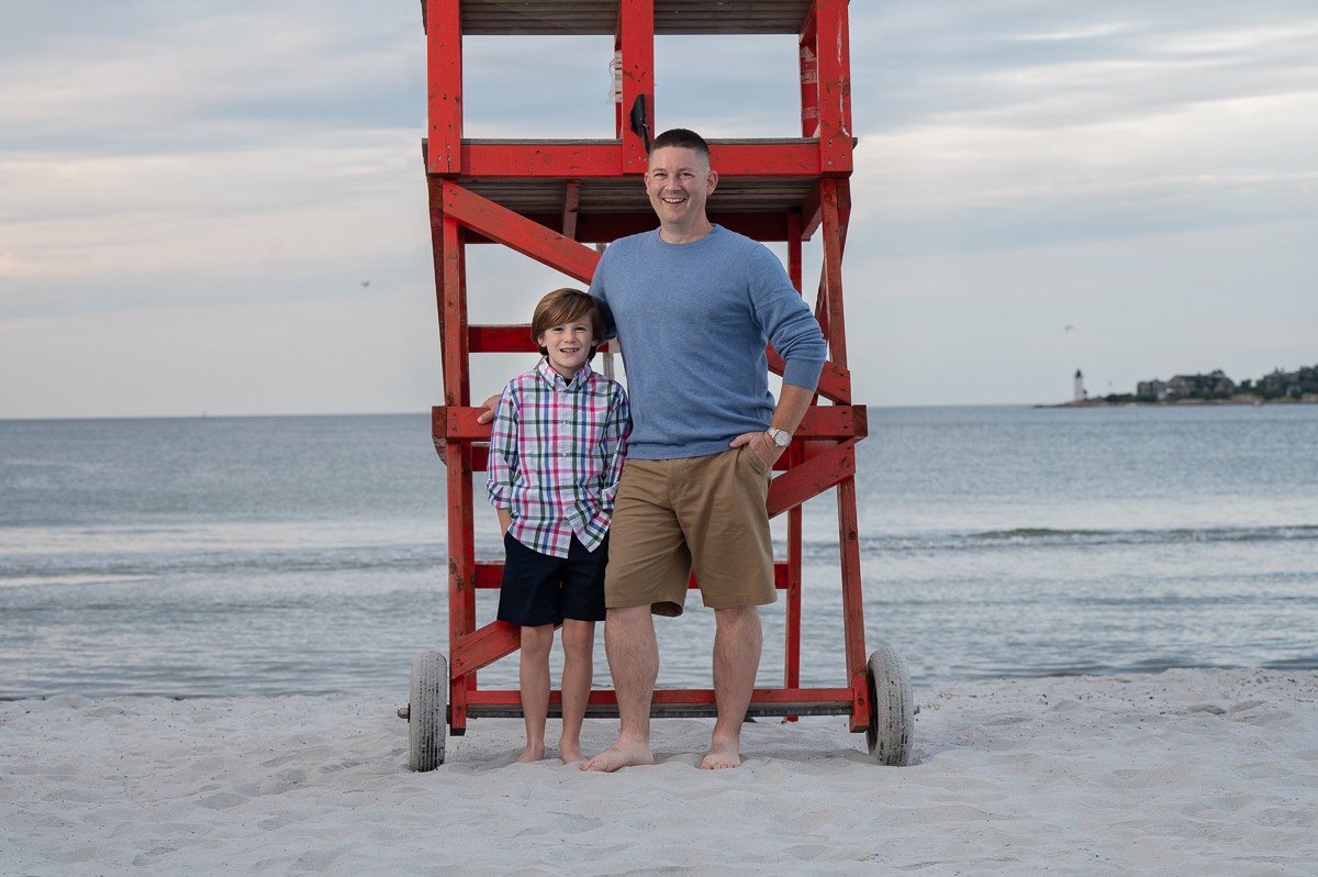 Father and son at the red lifeguard chair at Wingaersheek Beach in Gloucester MA